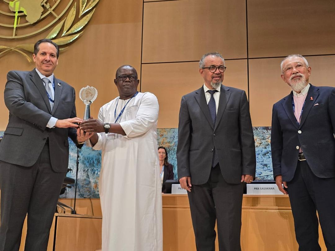 Représentant de l'ASACOBA recevant le trophée aux côtés du Directeur général de l'OMS